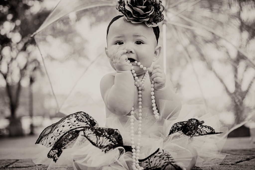 Baby with necklace under umbrella (Black and white)